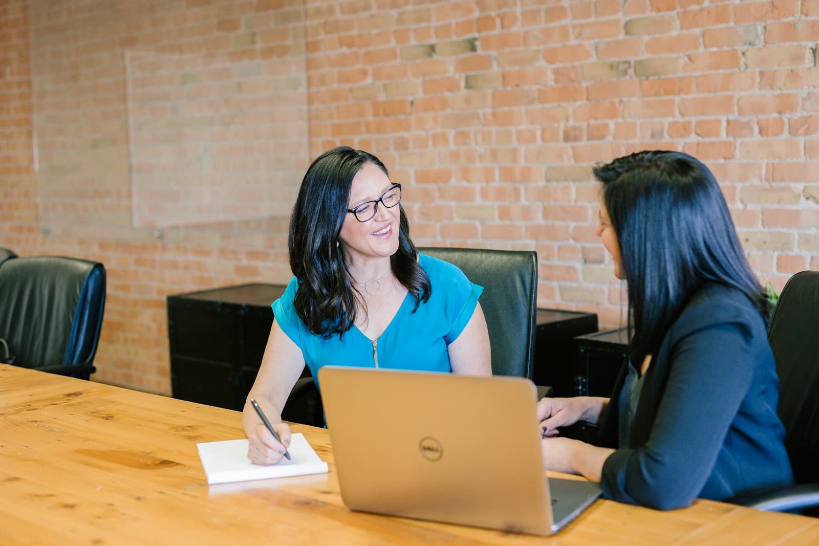 Two colleagues having a relaxed conversation at a worktable